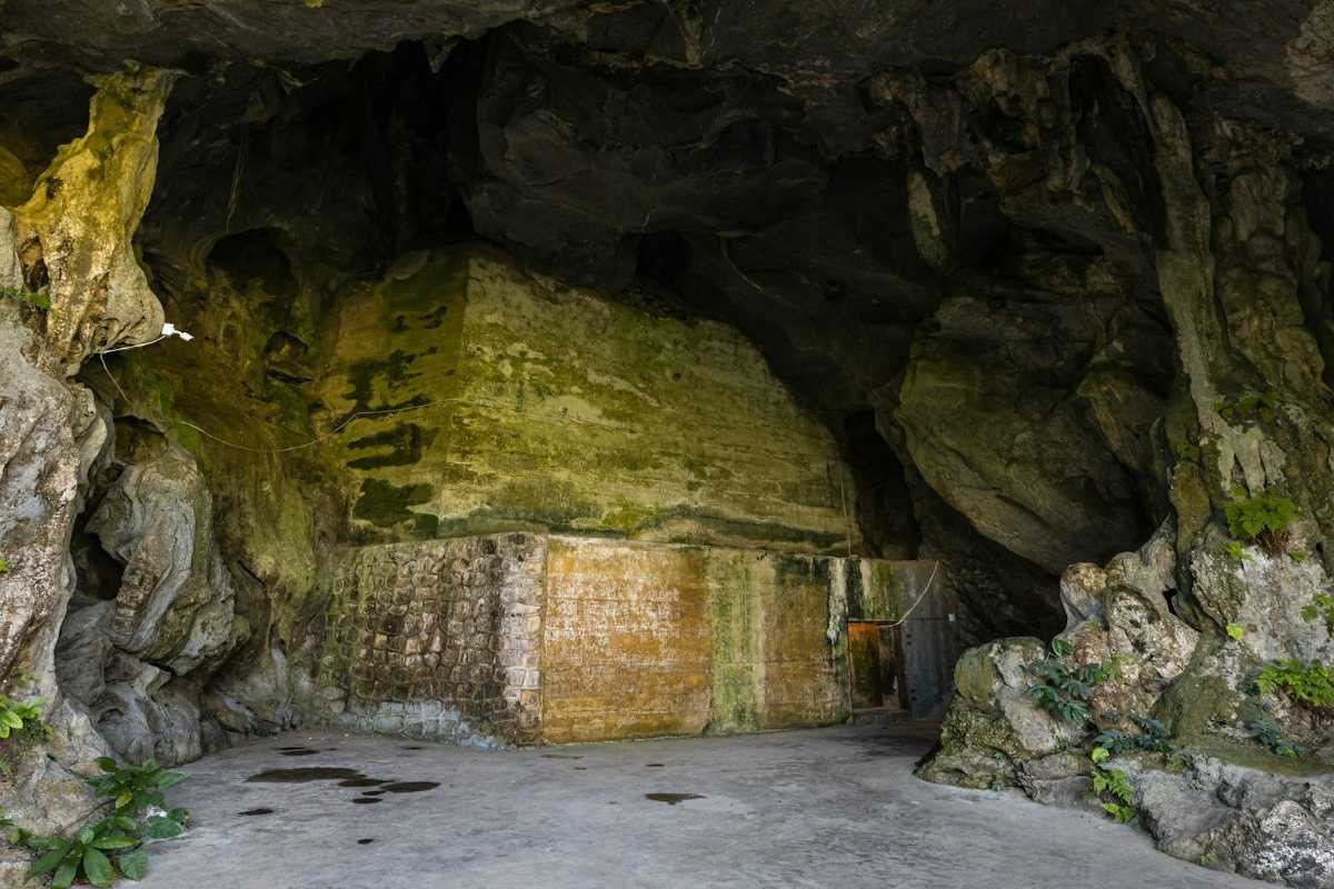 Dau Go Cave Halong Bay cave entrance pathway view View of the cave entrance pathway inside Dau Go Cave Halong Bay leading towards bright natural light outside.