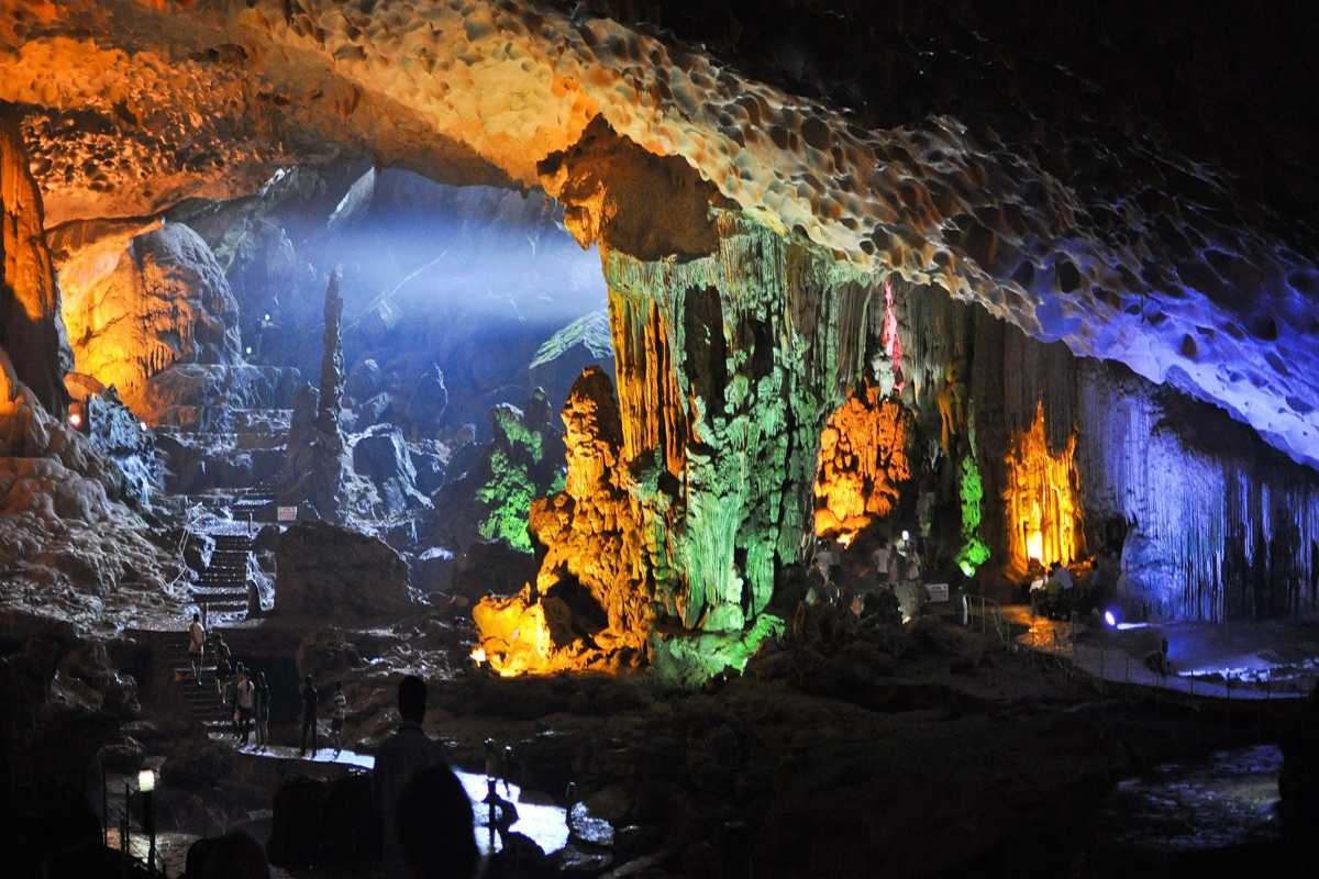 Dau Go Cave Halong Bay interior with sunlight beams Interior of Dau Go Cave Halong Bay featuring natural sunlight beams illuminating rocky formations and pathways.
