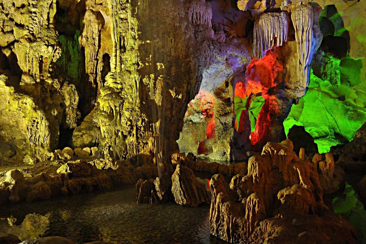 Dau Go Cave Halong Bay stalactites with colorful lights Dau Go Cave Halong Bay displays stunning stalactites illuminated by vibrant yellow, green, and red lights inside.