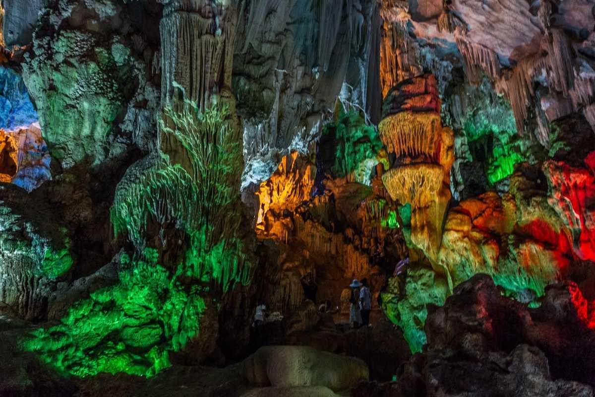 Dau Go Cave Halong Bay vibrant interior with colorful lights Vibrant and colorful interior lighting showcasing natural rock formations inside Dau Go Cave Halong Bay.