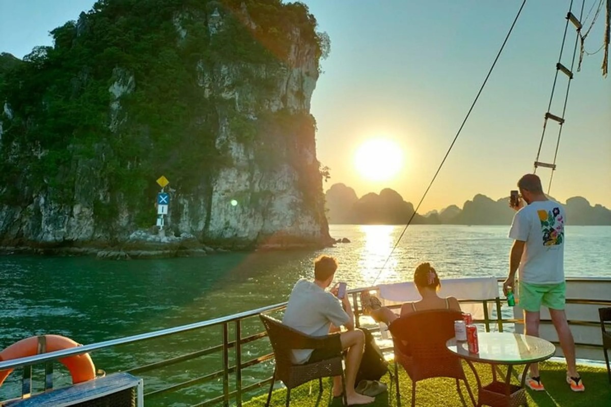 A day cruise in Halong Bay during sunset, capturing the serene beauty of Titov Island and its surrounding waters.