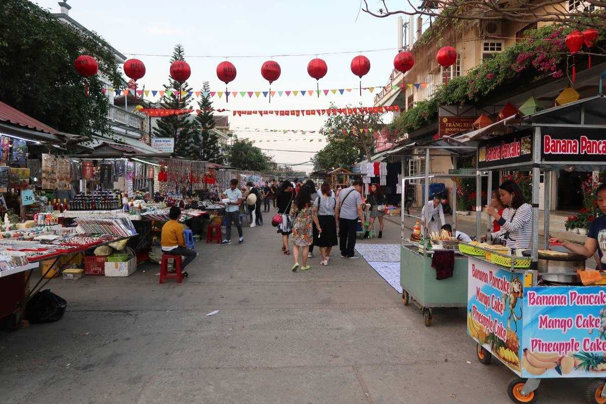 Daytime View of Busy Market Street at Hoi An Night Market Crowded market street with red lanterns overhead and stalls at Hoi An Night Market