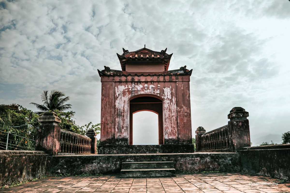 Front Tower of Dien Khanh Citadel at Dusk Close-up of Dien Khanh Citadel’s weathered red gate tower under cloudy evening sky.