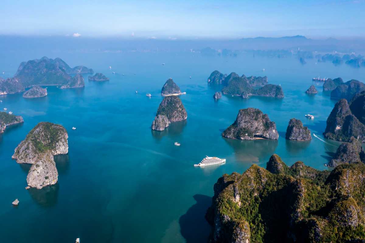 Dinh Huong Islet Halong Bay aerial view of limestone karsts Aerial view of Dinh Huong Islet Halong Bay showcasing limestone karsts surrounded by emerald waters and cruise boats