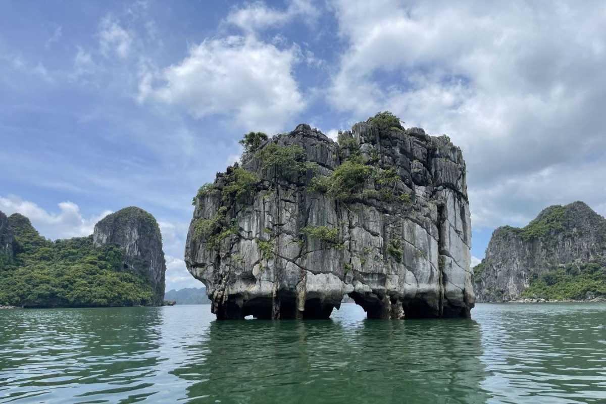 Dinh Huong Islet Halong Bay iconic limestone rock Iconic limestone rock of Dinh Huong Islet Halong Bay with surrounding cliffs and boats