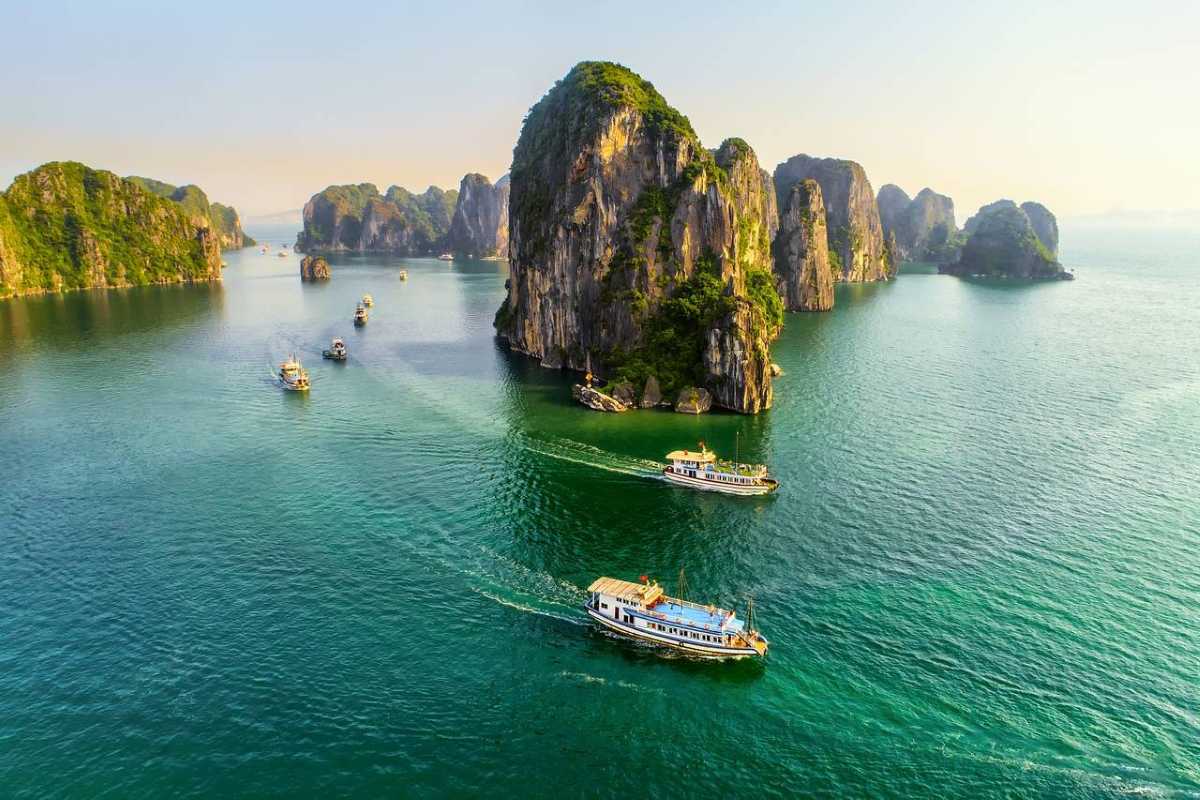 Dinh Huong Islet Halong Bay limestone islands at dusk Limestone islands at dusk in Dinh Huong Islet Halong Bay with boats cruising nearby