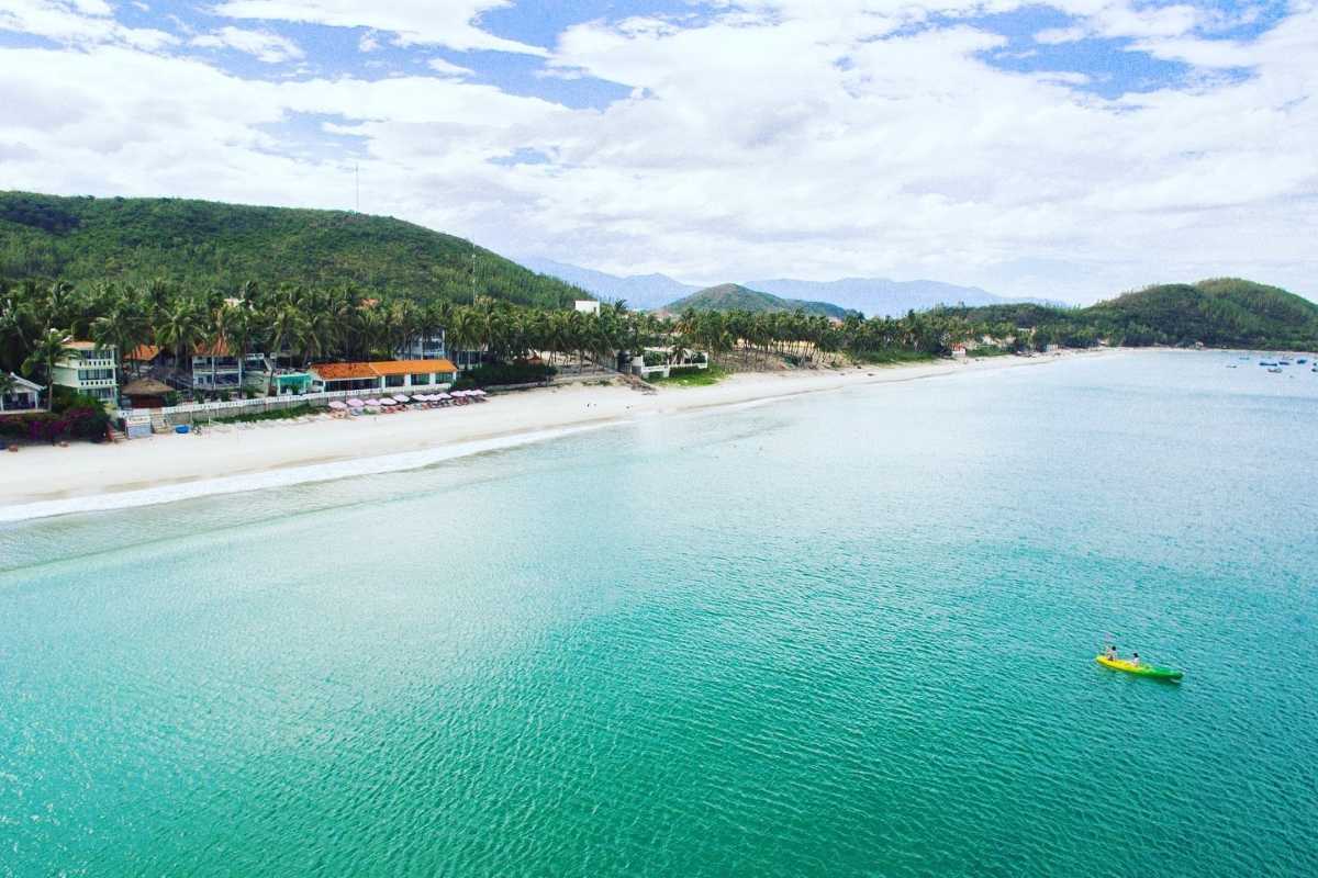 Coastal Resorts along Doc Let Beach Wide shot of resorts lining Doc Let Beach with calm waters, beachfront villas, and distant fishing boats.