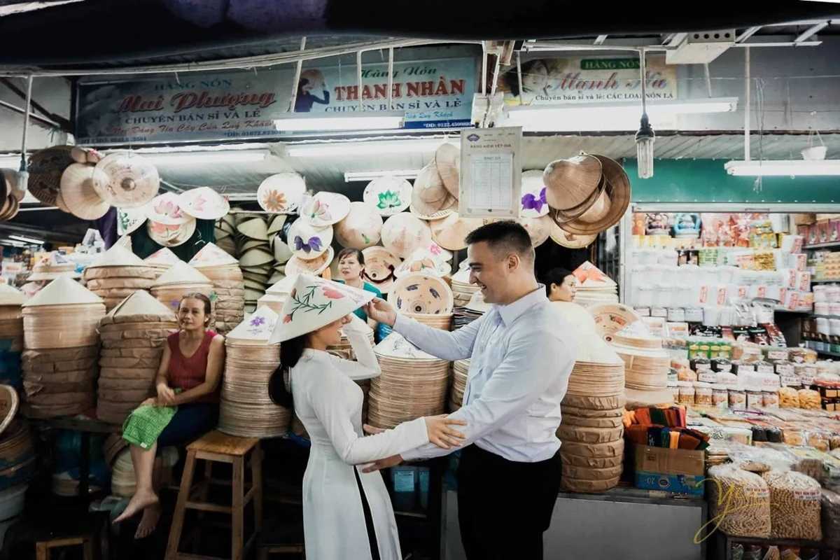 Couple Shopping for Non Bai Tho at Dong Ba Market A couple shops for Non Bai Tho conical hats at Dong Ba Market Hue, enjoying the local market experience