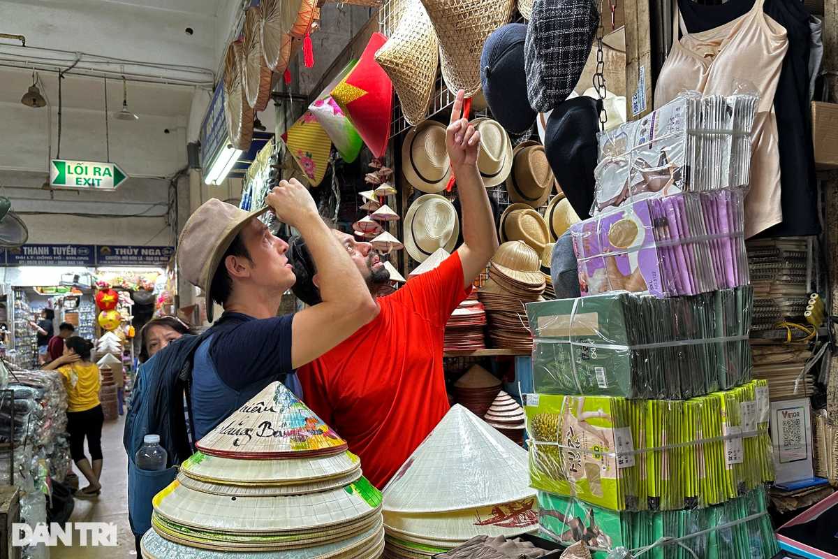 Traditional Vietnamese Hats at Dong Xuan Market Tourists browsing traditional Vietnamese hats and textiles inside Dong Xuan Market