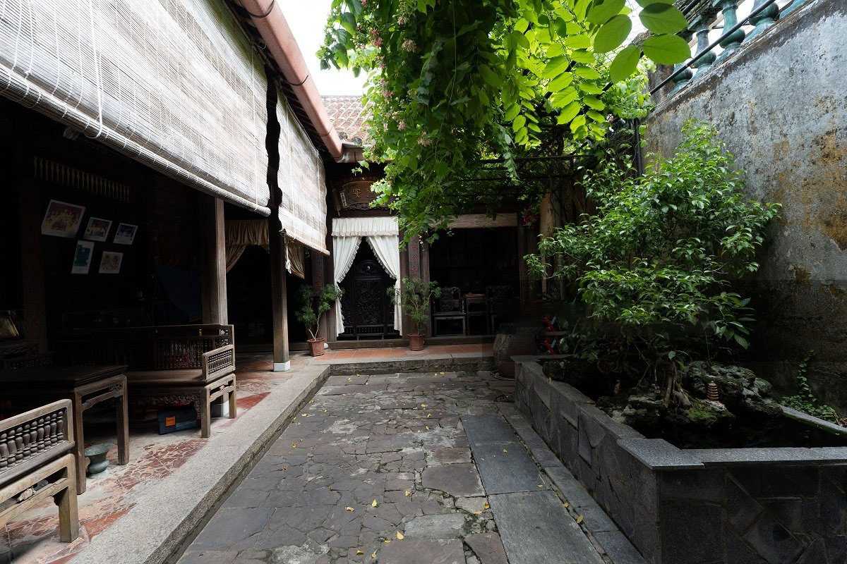 Courtyard and Garden Area at Duc An Old House Hoi An Spacious courtyard with stone pathway and lush green plants at Duc An Old House in Hoi An.