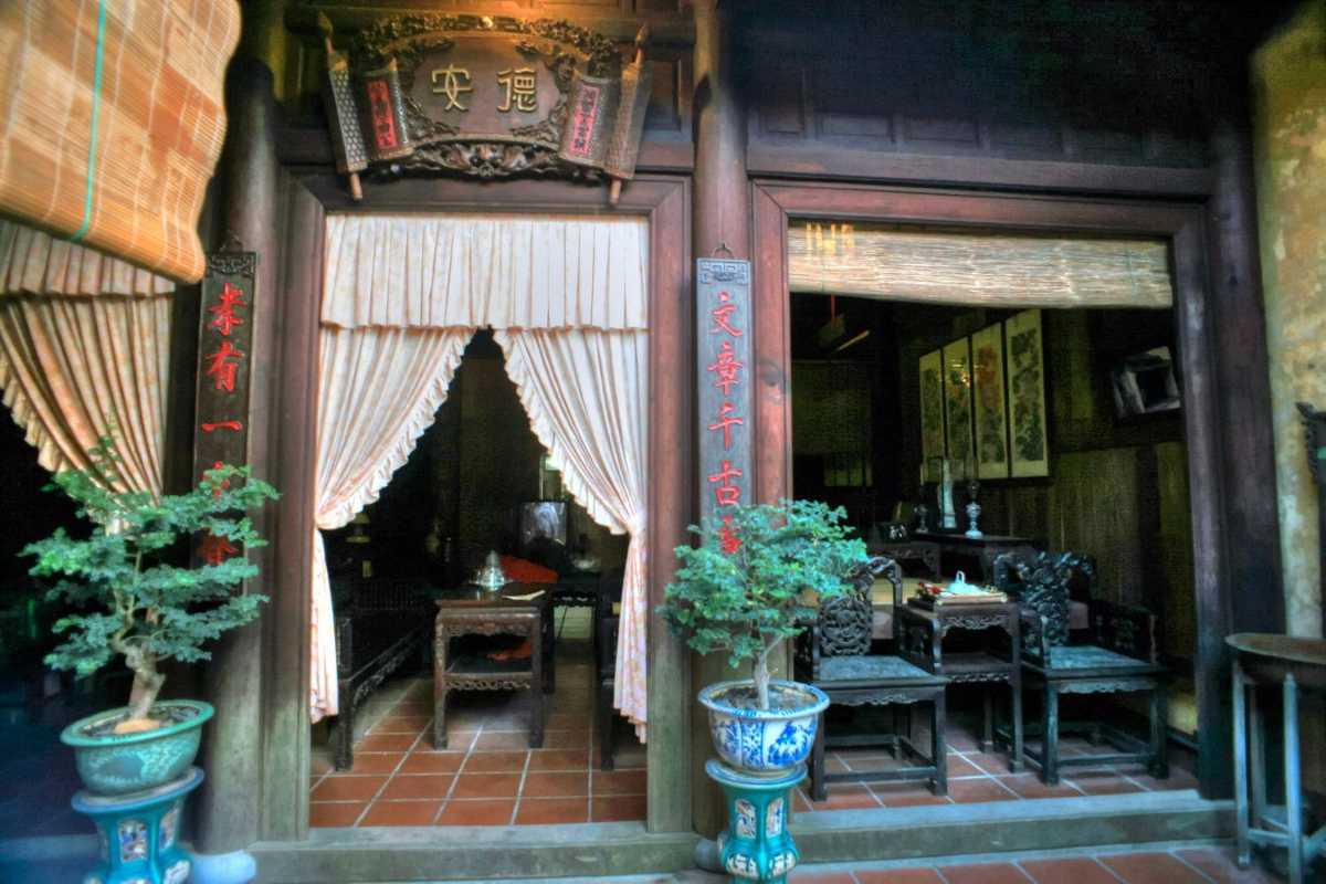 Front Exterior View with Signage at Duc An Old House Front exterior of Duc An Old House showing wooden facade and traditional signboards in Hoi An.