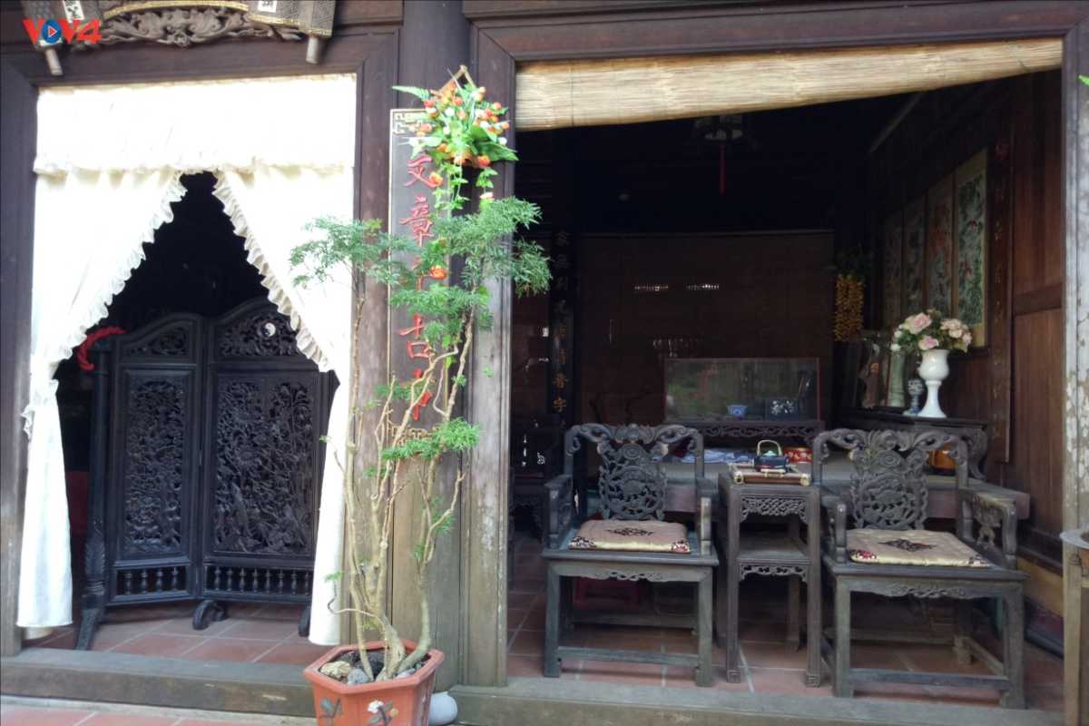Outdoor Seating Area at Duc An Old House Hoi An Outdoor wooden seating area with antique chairs and decorative plants at Duc An Old House.