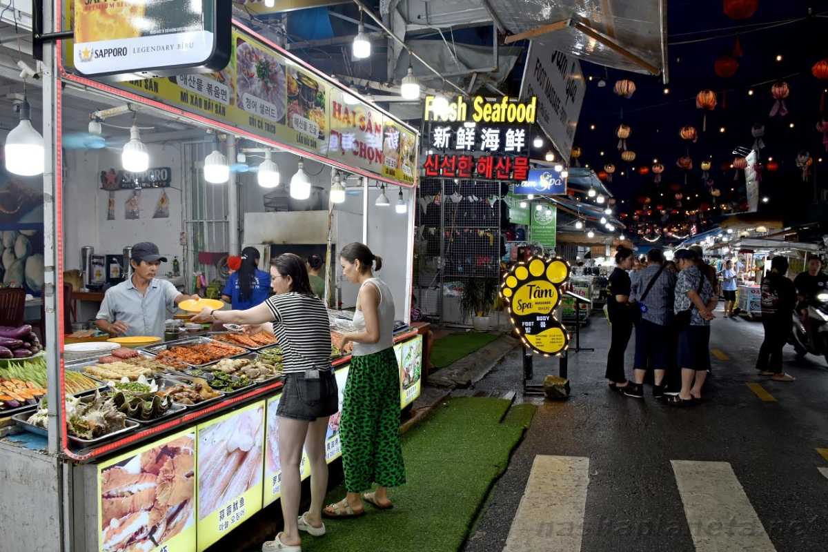 Nighttime seafood dining area at Duong Dong Night Market Outdoor dining area with seafood tables and lively crowd at Duong Dong Night Market Phu Quoc