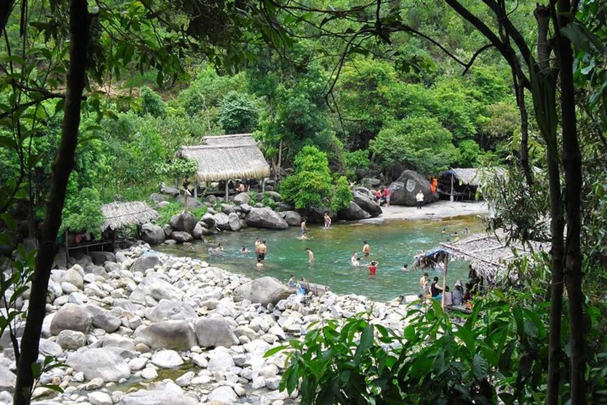 Elephant Springs forest view and swimming area Overview of Elephant Springs in Hue showing green jungle, huts, and tourists enjoying the spring water