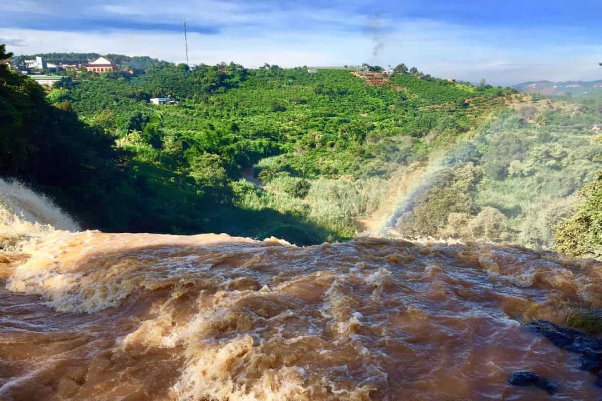 Elephant Waterfall Da Lat top view with rainbow Aerial top view of Elephant Waterfall Da Lat with a visible rainbow over the flowing water and surrounding green landscape