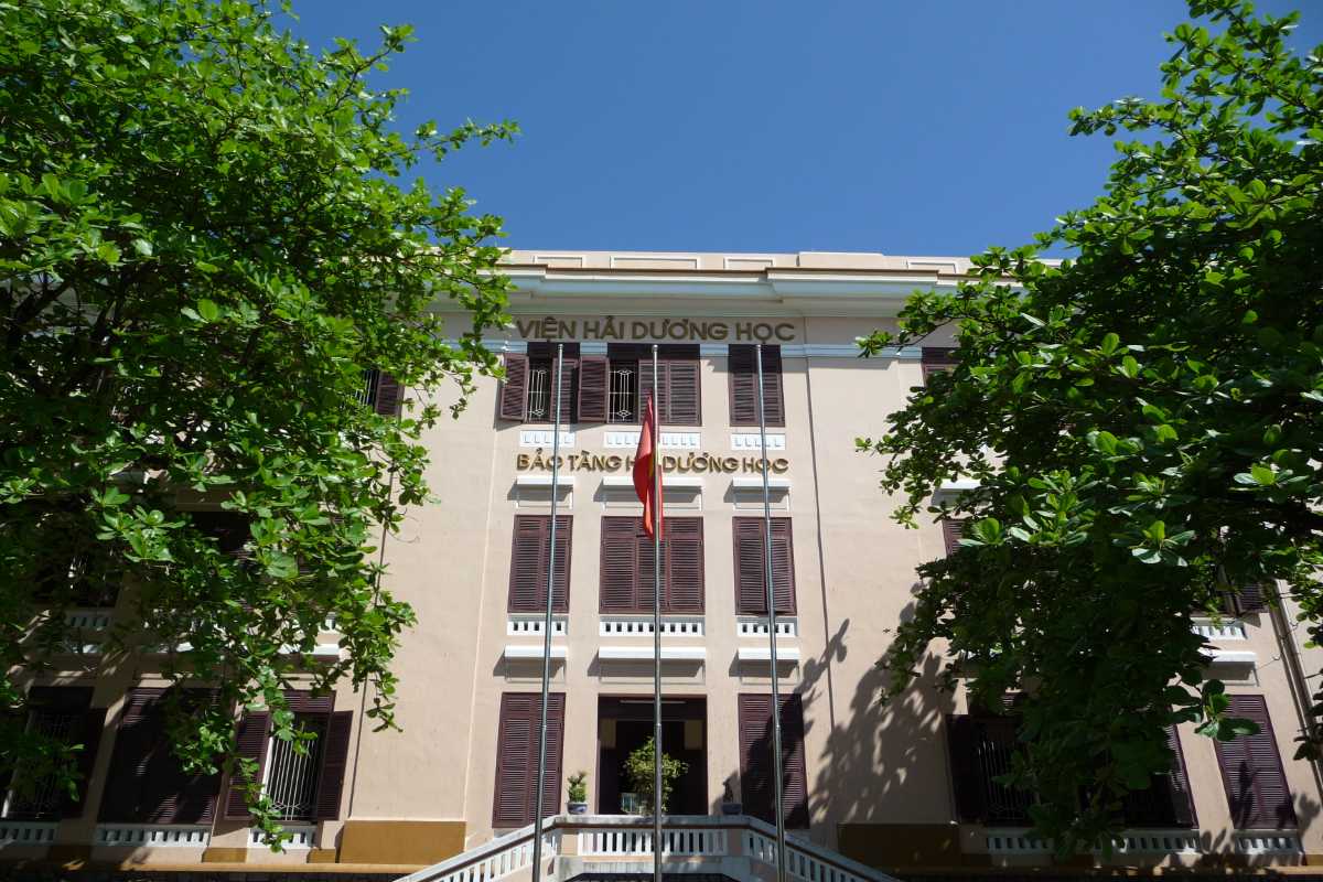 Main entrance of the Institute of Oceanography Facade of the Institute of Oceanography building in Nha Trang, shaded by green trees and marked by Vietnamese signage