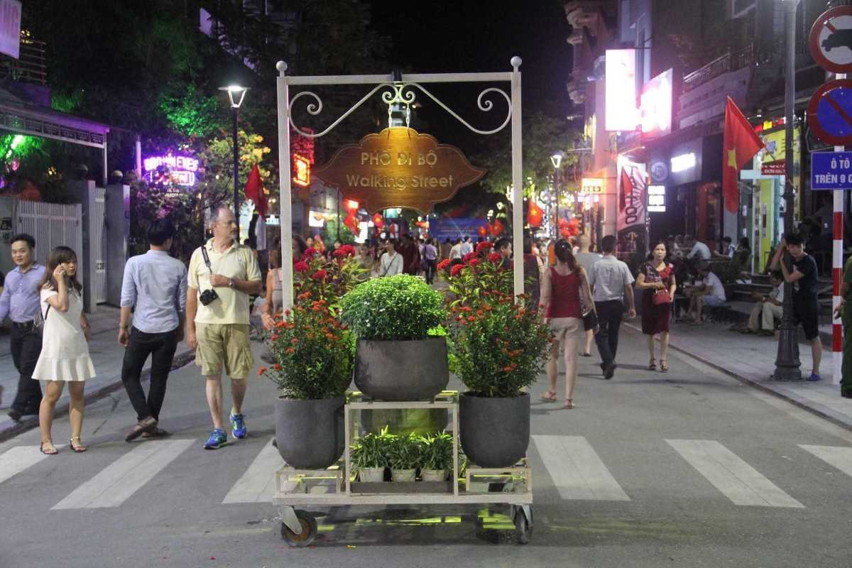 Entrance Sign to Nguyen Dinh Chieu Walking Street at Night Entrance sign with flowers and people walking on Nguyen Dinh Chieu Walking Street in Hue