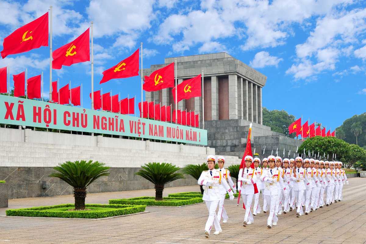 Evening Flags and Ho Chi Minh Mausoleum Rows of red flags with communist symbols and the Ho Chi Minh Mausoleum in the background