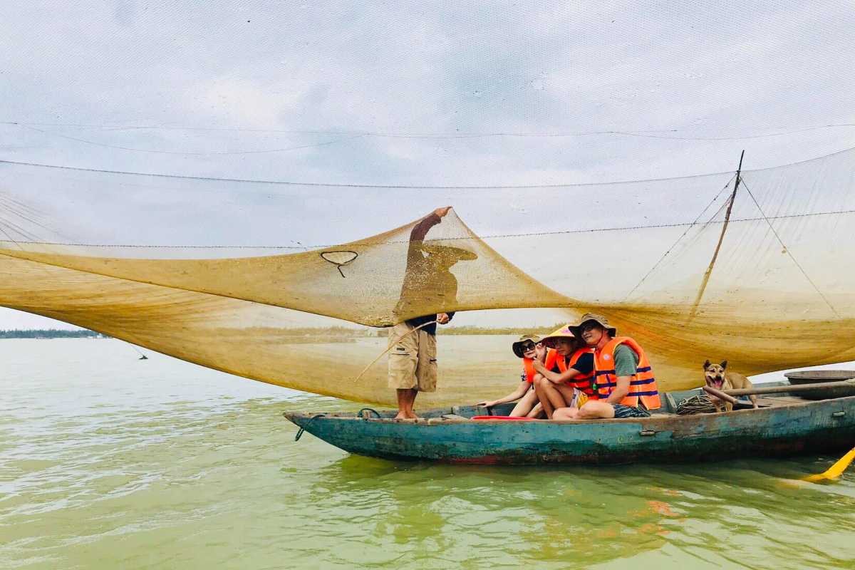 Family Boat Ride with Fisherman on Thu Bon River Family enjoying a boat ride while fisherman manages net on Thu Bon River