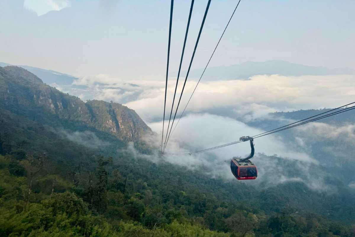 Fansipan Mountain Sapa cable car highland journey Fansipan Mountain Sapa cable car traveling above lush green forest valleys with low clouds and mist