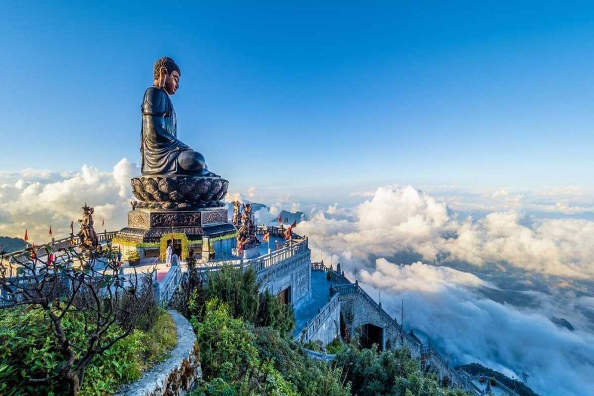 Fansipan Mountain Sapa Great Buddha statue above clouds Fansipan Mountain Sapa Great Buddha bronze statue overlooks sweeping clouds and distant mountains on clear day