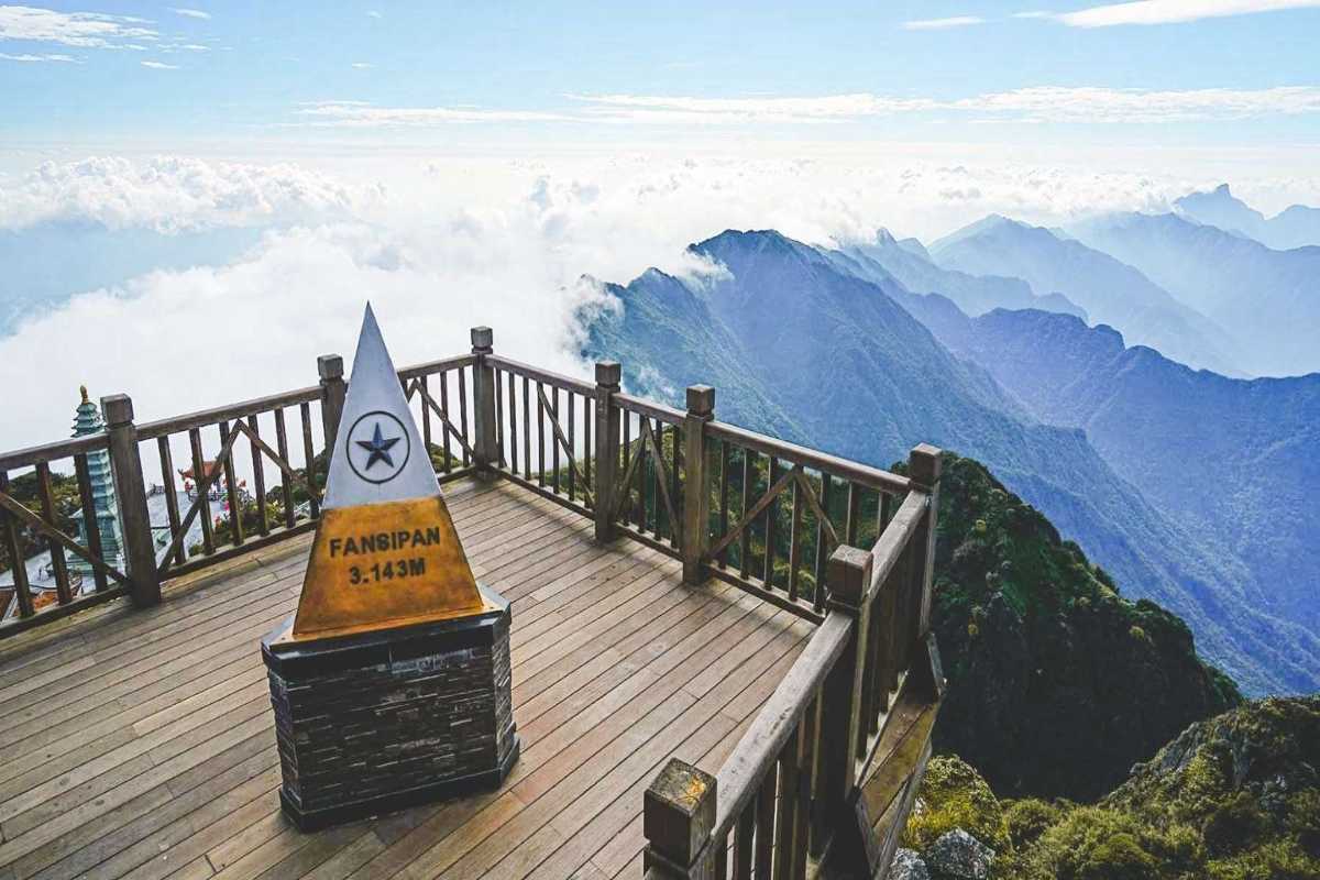 Fansipan Mountain Sapa summit marker panoramic platform Fansipan Mountain Sapa summit platform with pyramid marker and distant blue mountain ranges and clouds