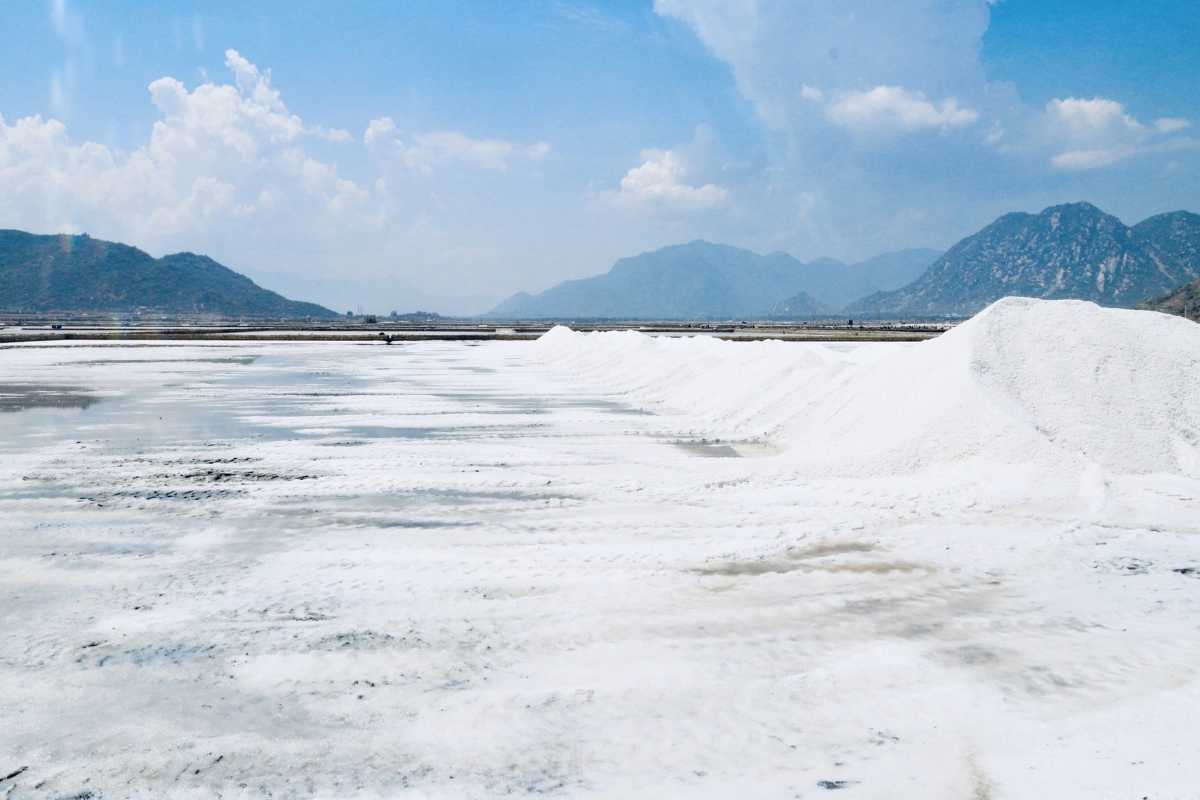 Farmers Carrying Salt Loads at Dam Vua Local salt farmers carrying baskets of harvested salt on shoulders at Dam Vua Salt Fields