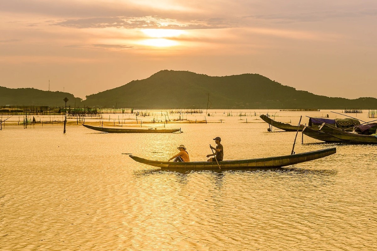 Fishermen on a boat at Tam Giang Lagoon during a stunning sunset