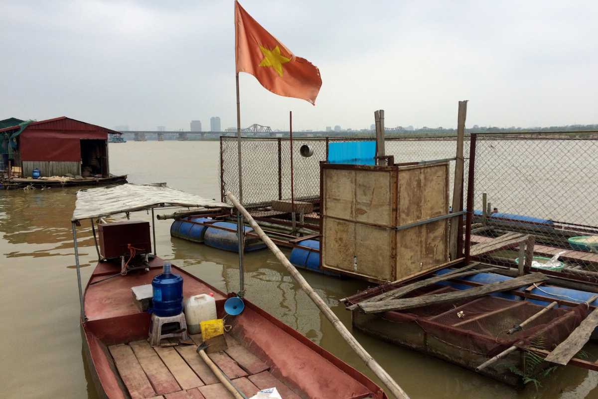 Floating House on the Red River Vietnam Small floating house with Vietnamese flag on the Red River Vietnam waters