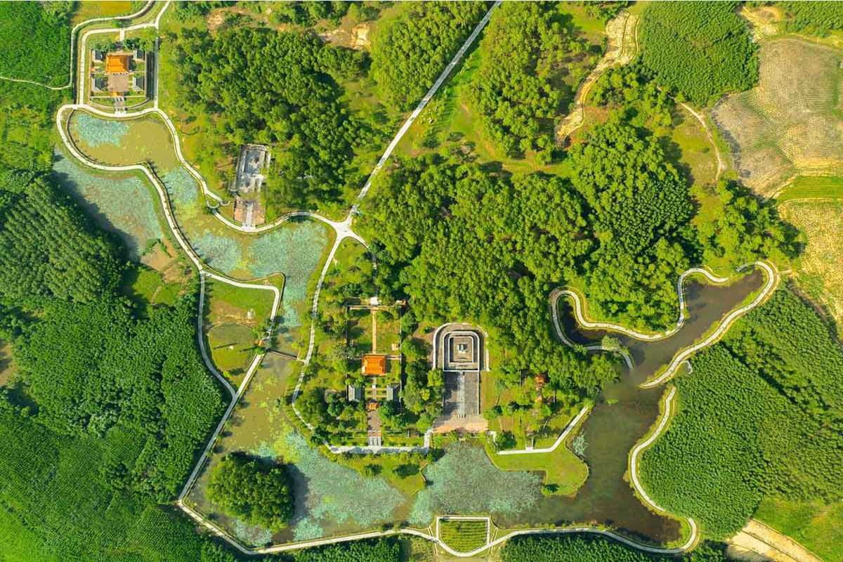 Gia Long Tomb Complex Aerial View with Forests Aerial view of Gia Long Tomb complex surrounded by pine forests, lotus ponds, and winding stone paths in Hue.