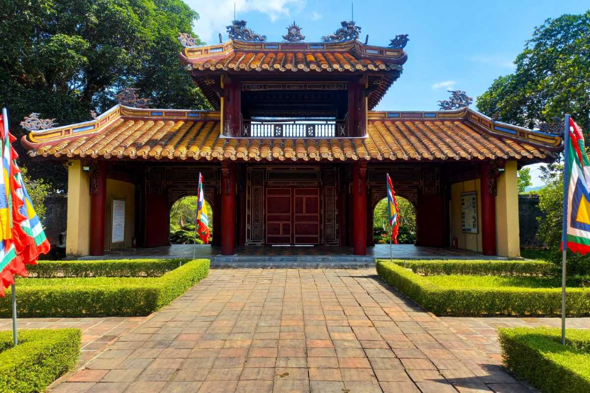 Main Entrance Pavilion of Gia Long Tomb Main entrance pavilion at Gia Long Tomb, featuring tiled roof, red columns, and imperial flags in Hue, Vietnam.