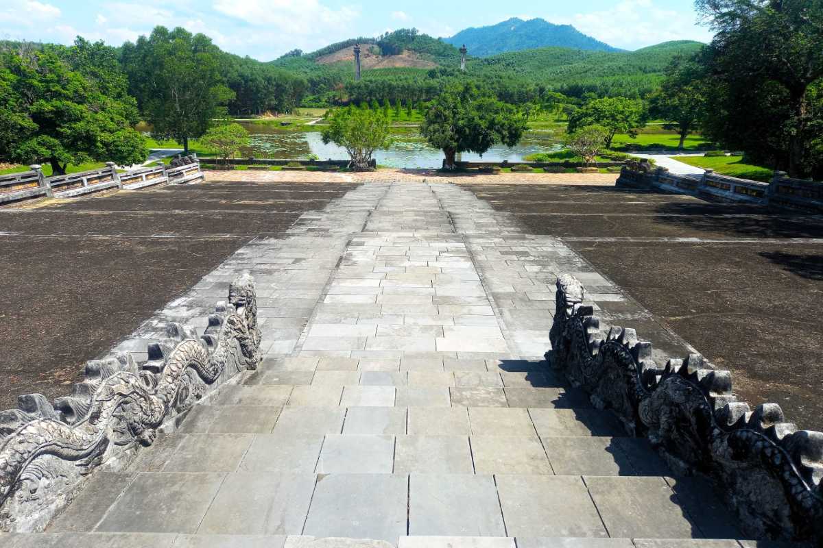 Panoramic Stone Terrace and Lotus Lake View Panoramic stone terrace overlooking lotus lake with mountains at Gia Long Tomb in Hue, Vietnam.