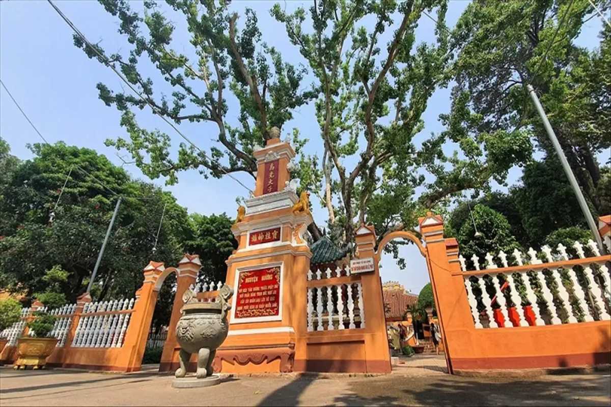Giac Lam Pagoda Courtyard and Entrance Pillars Ornate yellow courtyard entrance with large incense burner and pillars at Giac Lam Pagoda