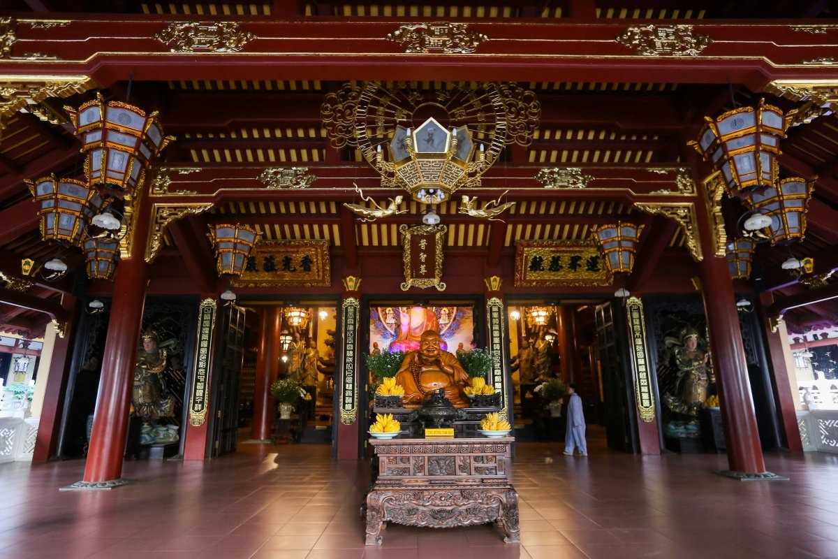 Giac Lam Pagoda Entrance with Buddha Statue Entrance hall of Giac Lam Pagoda with a statue of the Laughing Buddha and ornate decorations