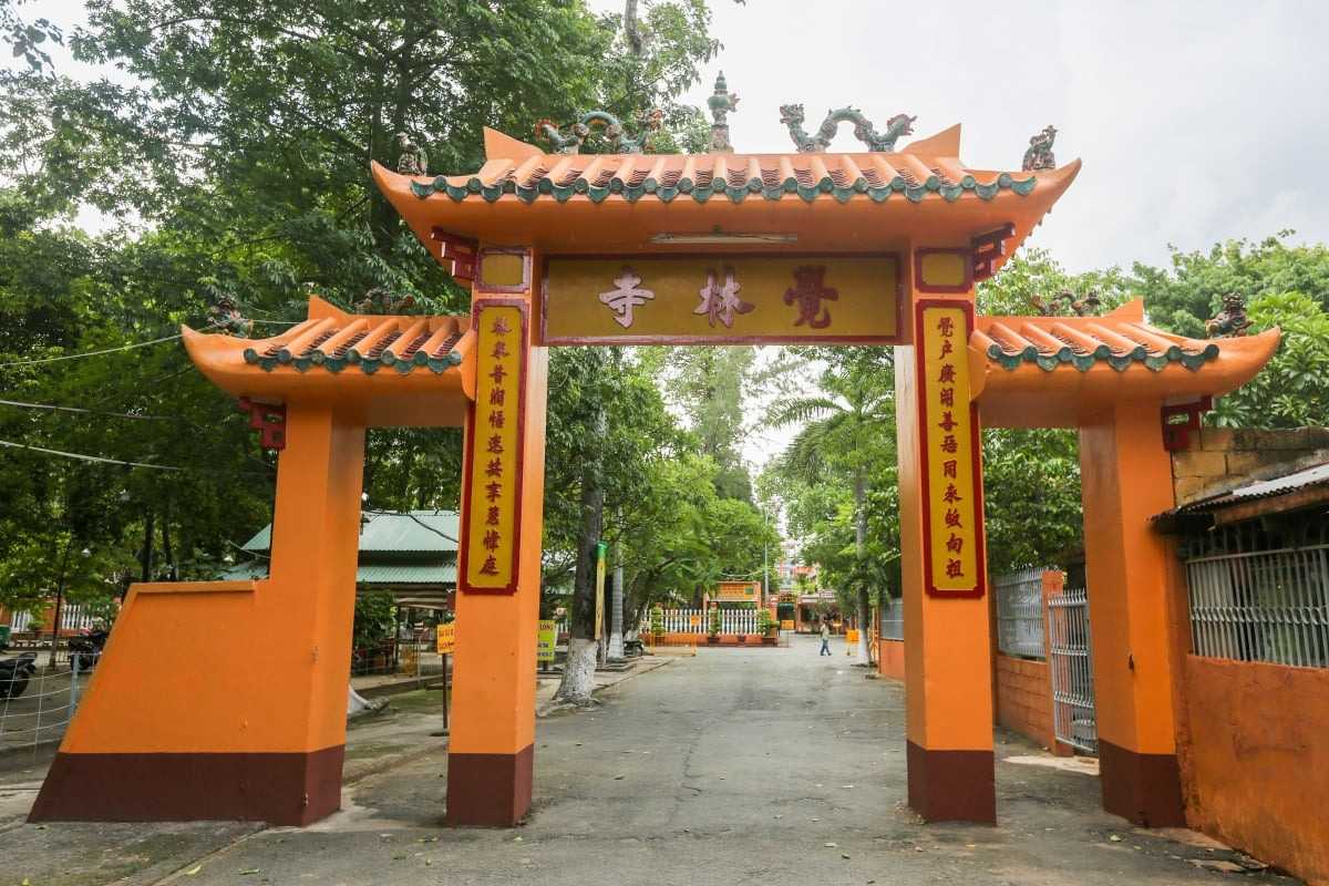 Giac Lam Pagoda Main Entrance Gate Large traditional yellow and orange entrance gate with Vietnamese script at Giac Lam Pagoda
