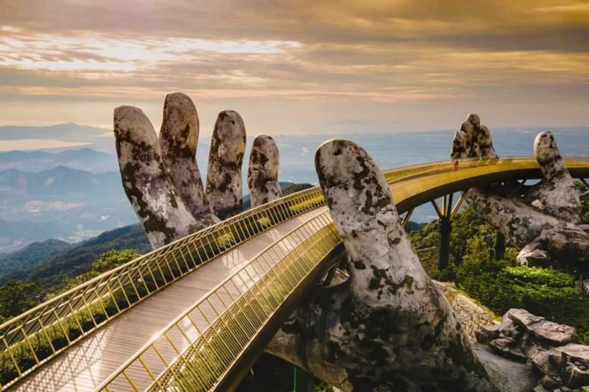 Golden Bridge Da Nang misty morning Ba Na Hills Golden Bridge Da Nang shrouded in morning mist, gold railings, hands emerging from clouds, mountain backdrop