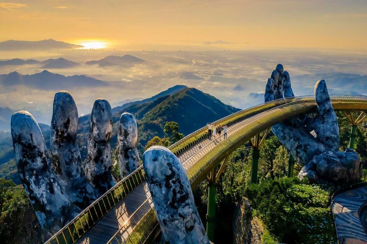 Golden Bridge Da Nang morning mountain panorama Morning light casts over Golden Bridge Da Nang, curved walkway with giant hands, hills and valleys