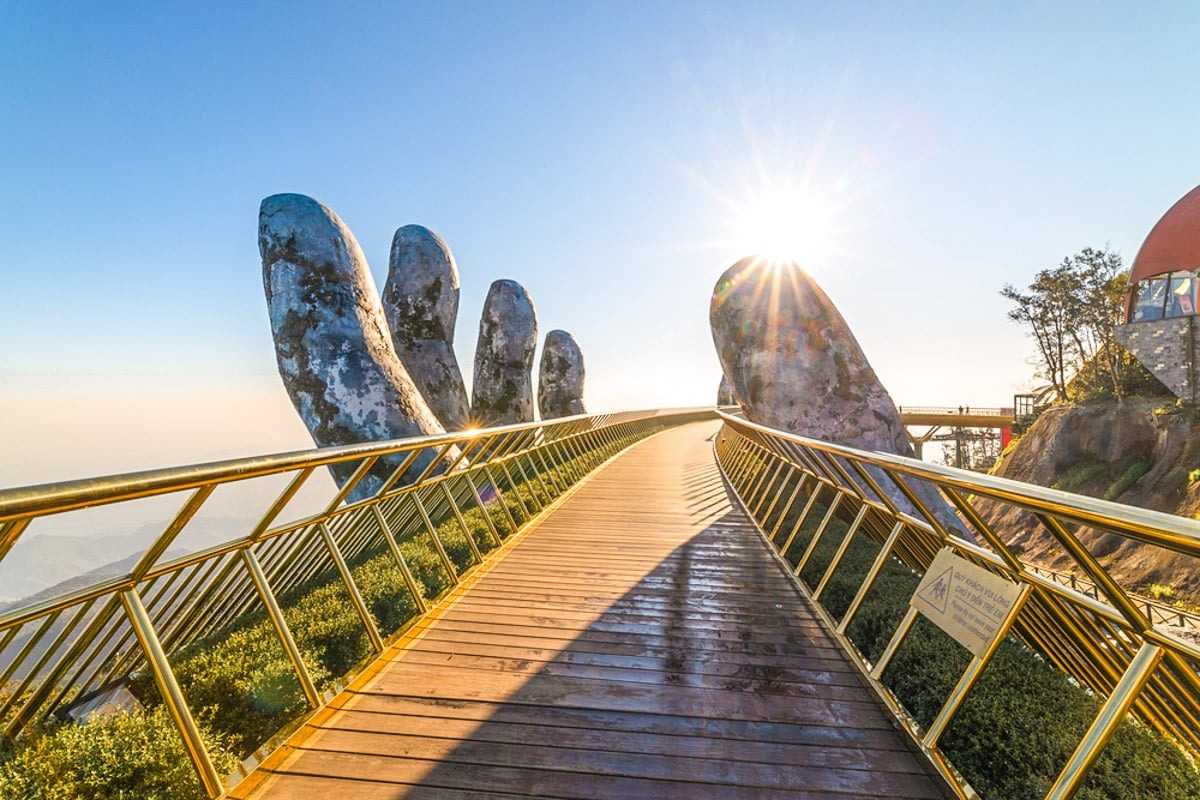 Golden Bridge Da Nang sunrise golden hand rails Sunrise shines over Golden Bridge Da Nang with massive hands and golden rails in Ba Na Hills