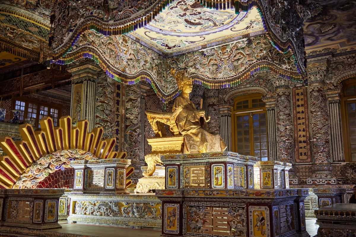 Golden statue inside Thien Dinh Palace Golden statue of Emperor Khai Dinh inside Thien Dinh Palace surrounded by ornate mosaics and murals