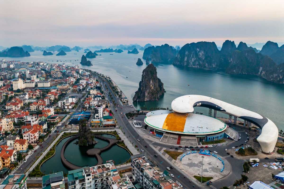 Ha Long Bay Aerial View of City and Islands Aerial view of Ha Long City with limestone islands scattered in the bay under soft sunset light.