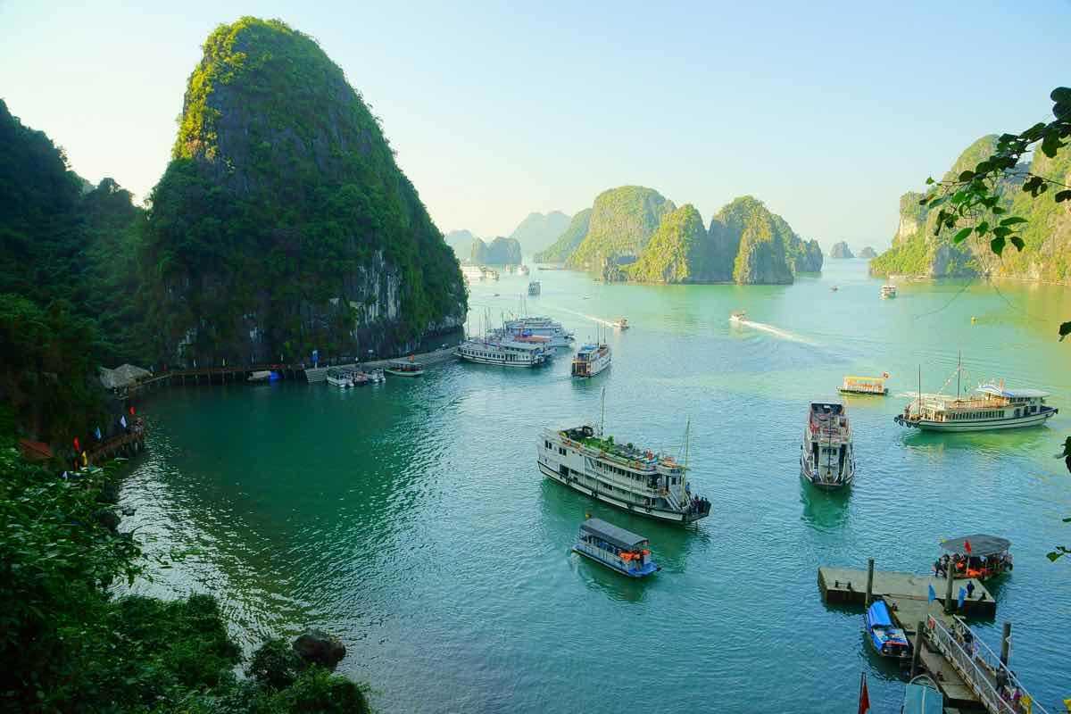 Floating Fishing Village in Ha Long Bay Traditional floating fishing village houses with colorful roofs on calm water surrounded by limestone karsts.