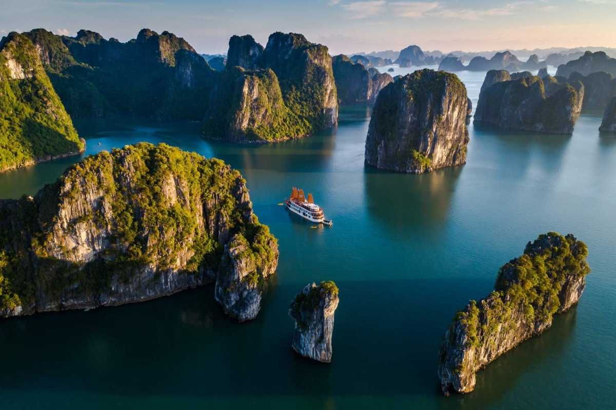 Ha Long Bay Limestone Islands and Cruise Boats Limestone islands covered in greenery with cruise boats navigating the calm waters of Ha Long Bay.