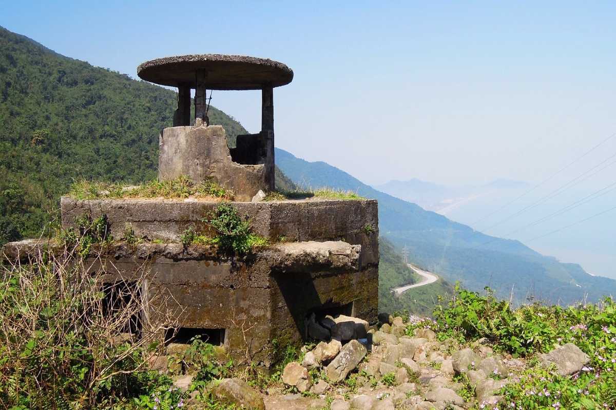 Hai Van Pass historic French bunker overlooking coastline Hai Van Pass historic French bunker stands on a green hillside, overlooking coastal curves and distant beaches.