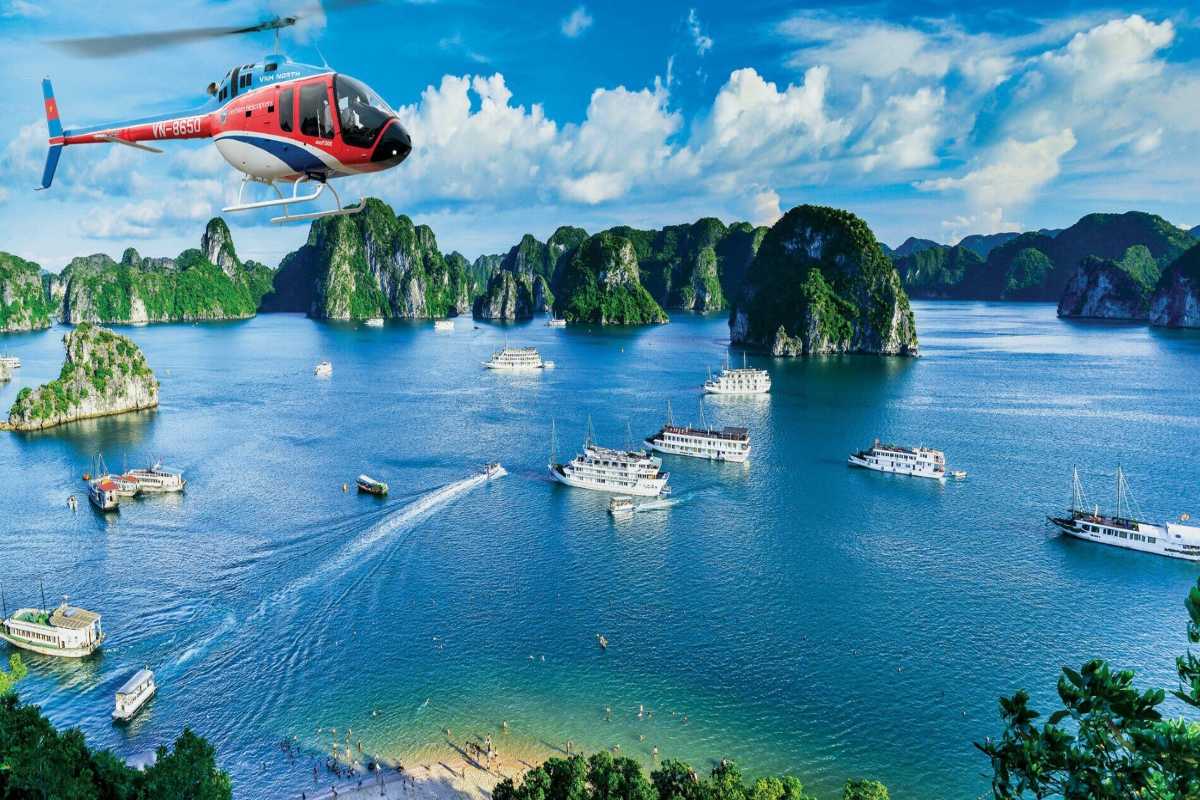 Halong Bay tourist boats sailing near limestone islands Tourist boats cruising near limestone islands in Halong Bay close to Drum Cave, offering scenic tours.