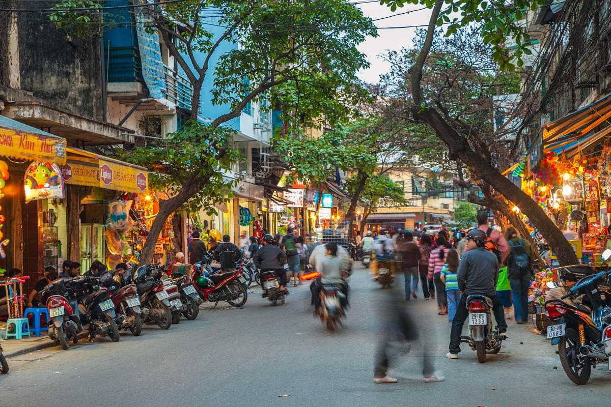 Hanoi French Quarter Bustling Street Scene Crowded street with motorbikes and pedestrians in Hanoi French Quarter at dusk