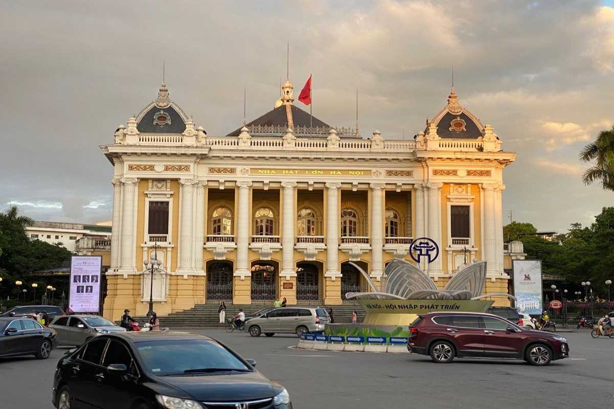 Hanoi Opera House Front View on Rainy Day Front facade of Hanoi Opera House with motorbikes passing on a rainy day