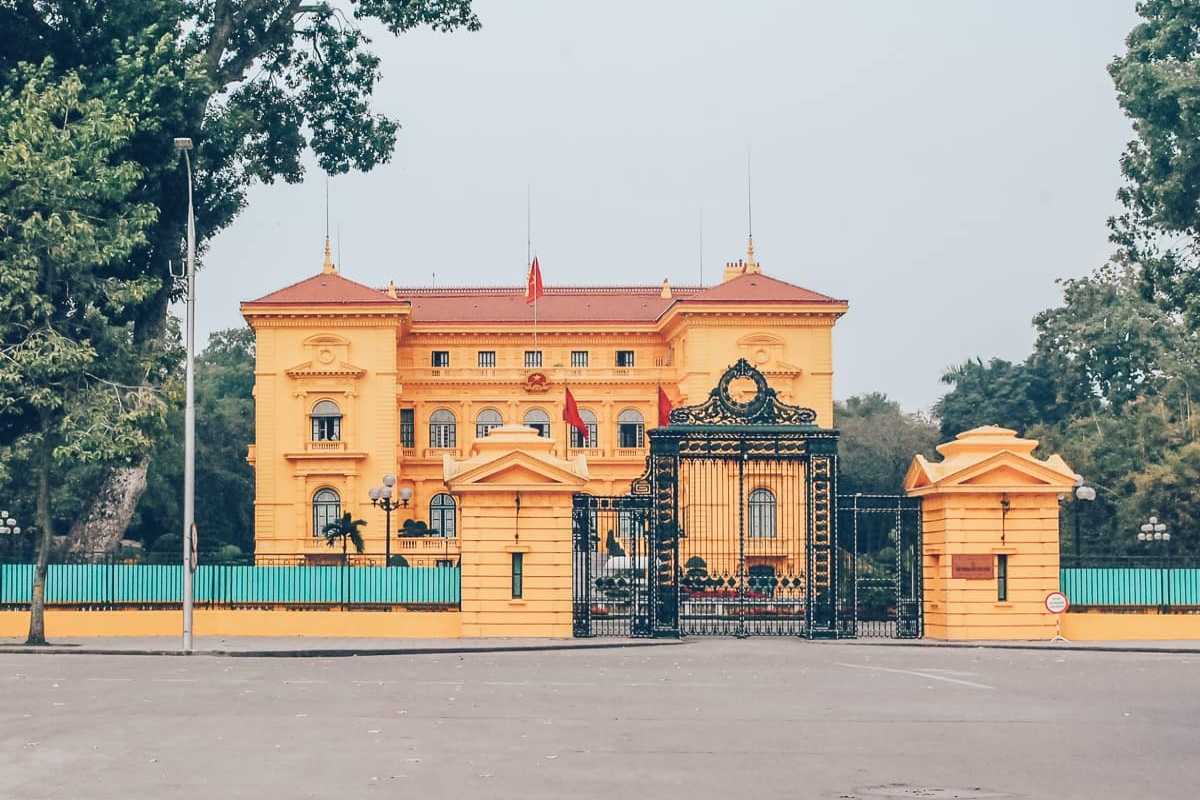 Hanoi Presidential Palace Front Entrance from Across Road View of the Hanoi Presidential Palace entrance from across the road with black iron gates