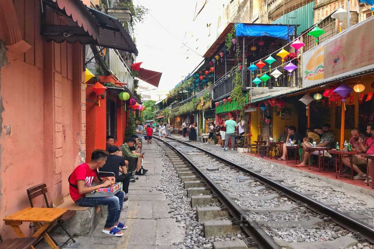 Relaxed Atmosphere at Hanoi Train Street Cafes Visitors sitting and relaxing at small cafes beside Hanoi Train Street railway tracks