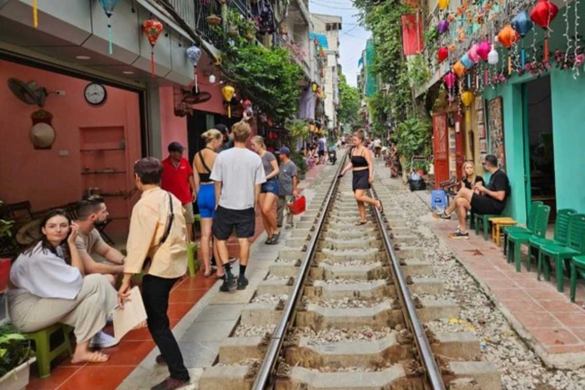 Daytime Hanoi Train Street Crowds and Cafes Tourists and locals gathered along Hanoi Train Street railway tracks during the day