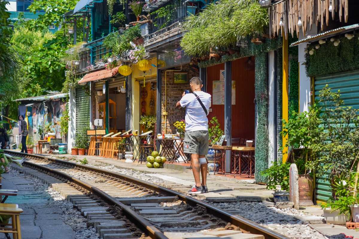 Tourists and Locals at Hanoi Train Street Diverse visitors and locals enjoying the bustling Hanoi Train Street environment